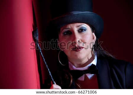 Woman dressed like a circus ringmaster with leather crop
