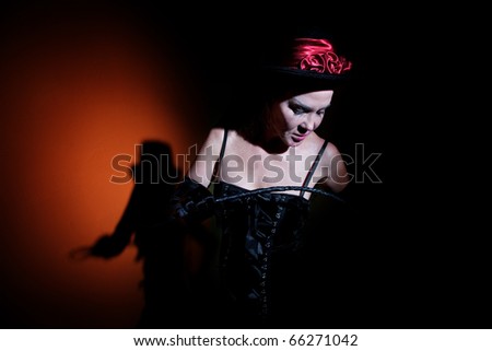 Pale looking woman dressed in black with whip