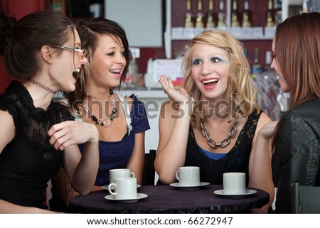 Four college freshmen chatting in a coffee shop