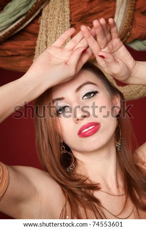 Beautiful young belly dancer with hands above her head