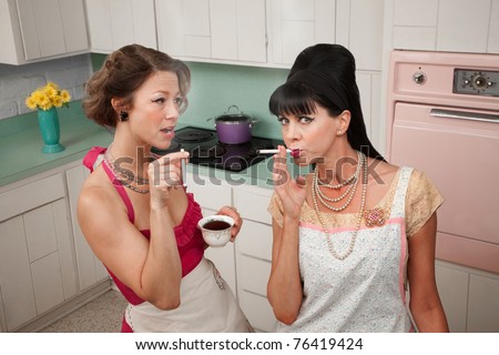 Two middle-aged retro styled women smoking cigarettes and having coffee