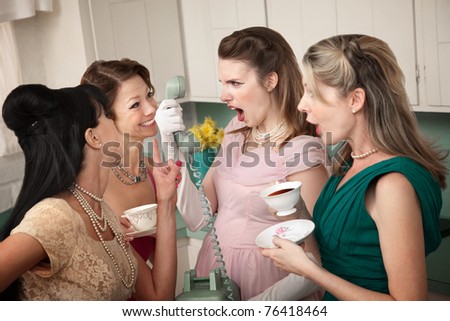 Angry woman on phone with three friends in a kitchen