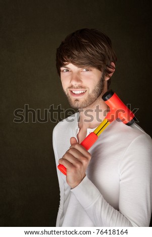 Smiling young man with red and yellow mallet