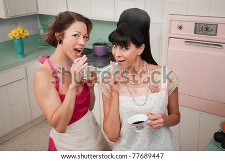 Two women smoke cigarettes while having coffee in a retro kitchen scene
