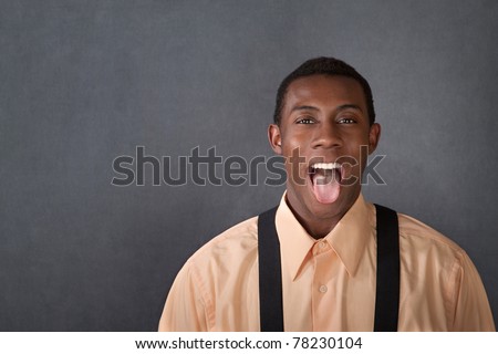 Happy young Black man sticks out his tongue