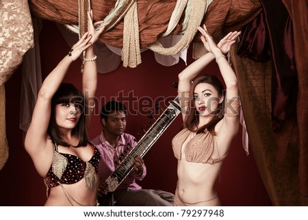 Two beautiful Arab belly dancers with Indian man playing Sitar