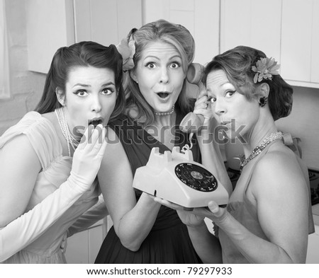 Three pretty women in kitchen with telephone