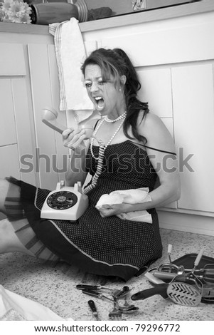 Crazed woman sitting on the kitchen floor yells at her telephone