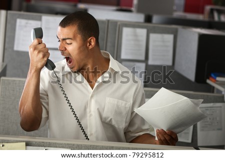 Angry Latino office worker yells on phone