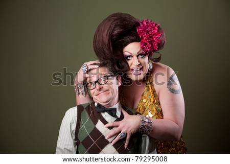 Drag queen holds a Caucasian nerd on green background