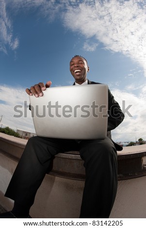 Excited African-American businessman relaxes while working on his laptop