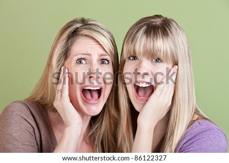 Mother and daughter scream with hands on their faces