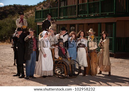 Large group of men and women in old west theme with guns