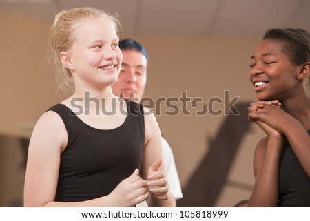 Young ballet students laughing together at dance class