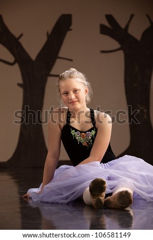 Teenage girl in ballet dress sitting on the floor