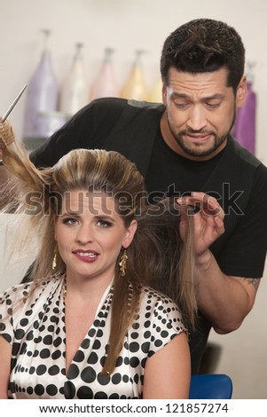 Attractive female with hair problem and embarrassed hair stylist