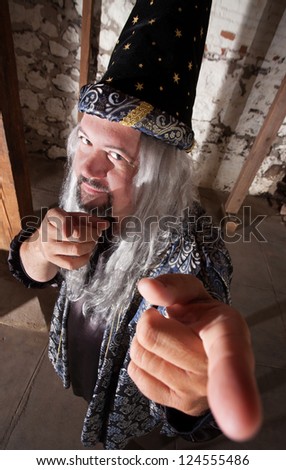 One smiling bearded wizard pointing his fingers