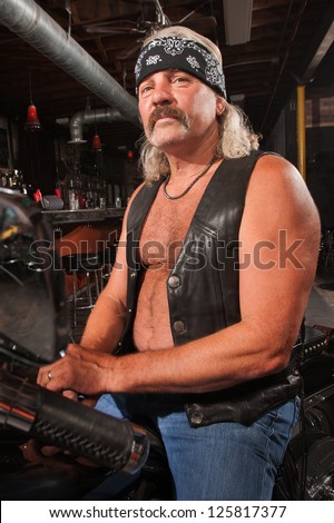 Tough middle aged man on motorcycle in bar