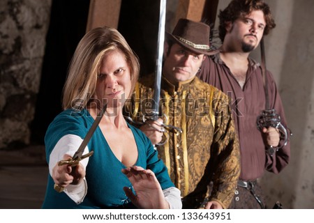 Tough smirking medieval woman with dagger and friends