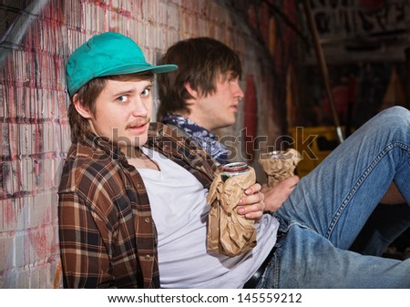 Two drunk young European men sitting outside