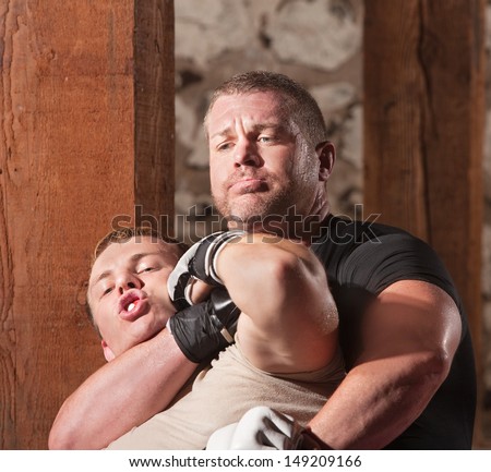 Blond mixed martial arts fighter being choked from behind