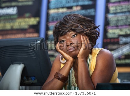 Bored African woman with apron behind restaurant counter