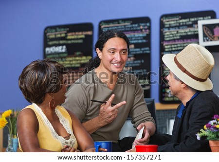 Handsome cafe owner with diverse customers taking orders