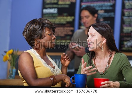 Pair of calm women in conversation at coffee house