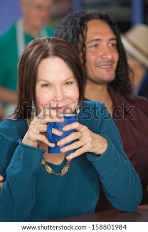 Cheerful mature woman in cafe with handsome male friend