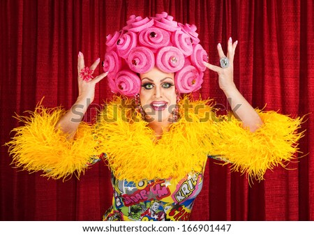 Happy man in dress and pink foam wig performing