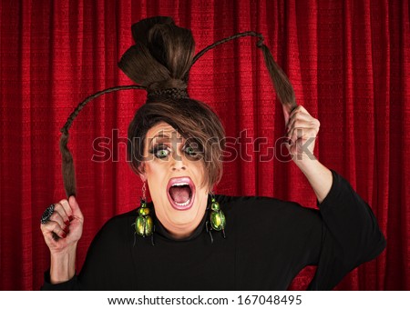Desperate white drag queen over curtain pulling ponytails