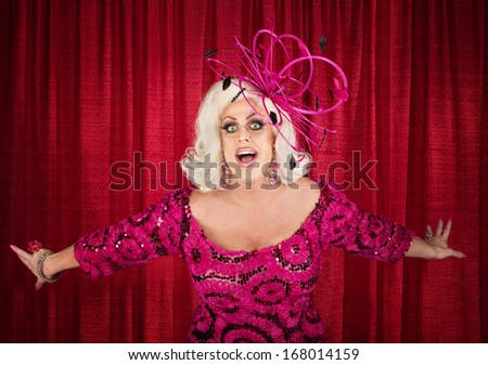 Happy drag queen in blond with singing in theater