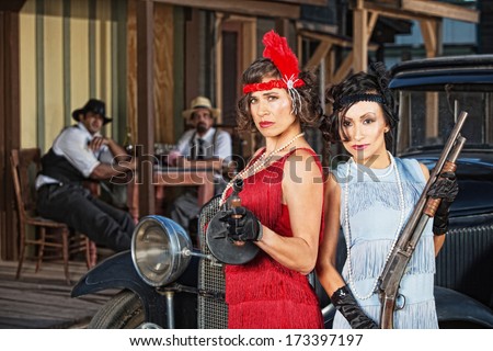 Stylish female 1920s gangsters with weapons