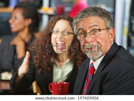 Frustrated businessman arguing with woman in cafeteria