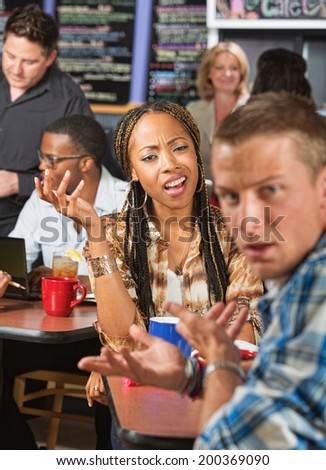 Mixed Black and white couple arguing in a cafe