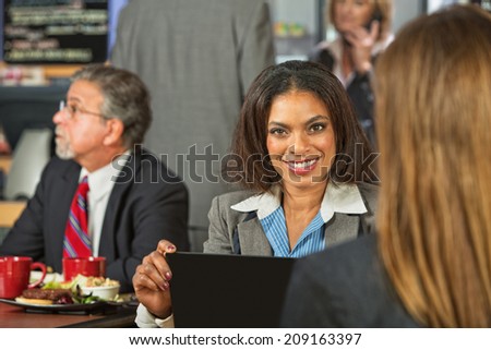 Smiling beautiful business woman with friend in cafe