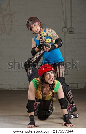 Hostile roller derby skater attacking woman with leg twist