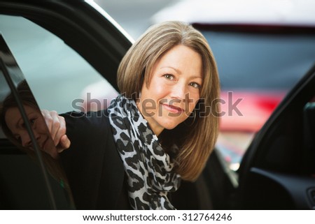 Optimistic executive business woman sitting inside car