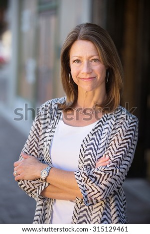 Beautiful confident single Caucasian woman with folded arms