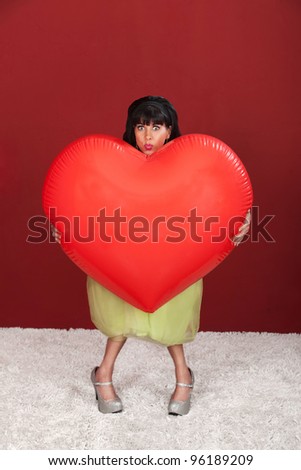 Retro-styled woman with big heart shaped balloon