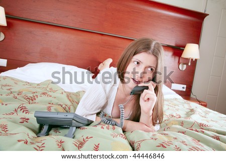 Young woman calling for room service in hotel interior
