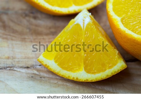 Organic orange fruit. Slices on wooden background