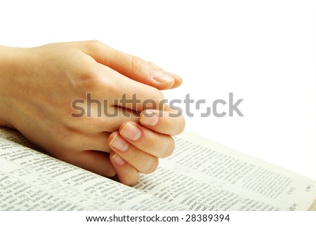 hands clasped in prayer over a bible