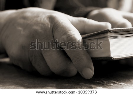 Old woman\'s hands keeping a Bible