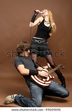 An image of a man with guitar and a woman with microphone
