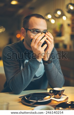 man in coffee shop using smart phone