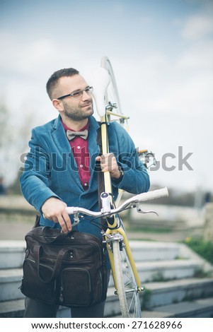 Young stylish man holding fixed gear bicycle walking in the city, handsome hipster man walking, fashion model man posing with fixed gear bicycle