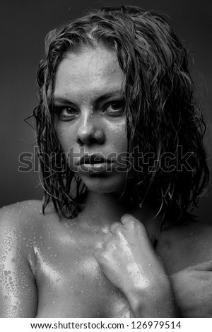 Portrait of a girl's face which water flows on a dark background.