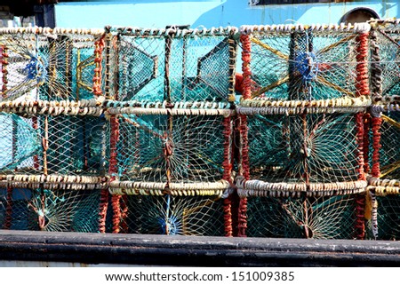 Lobster pots or traps stacked on a boat, ready for the next catch.  Old fishing boat in Houtbay harbor, Cape Town.