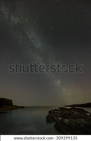 The Milky Way over the coastline of Anglesey in North Wales, showing light pollution and the phenomenon of air glow.